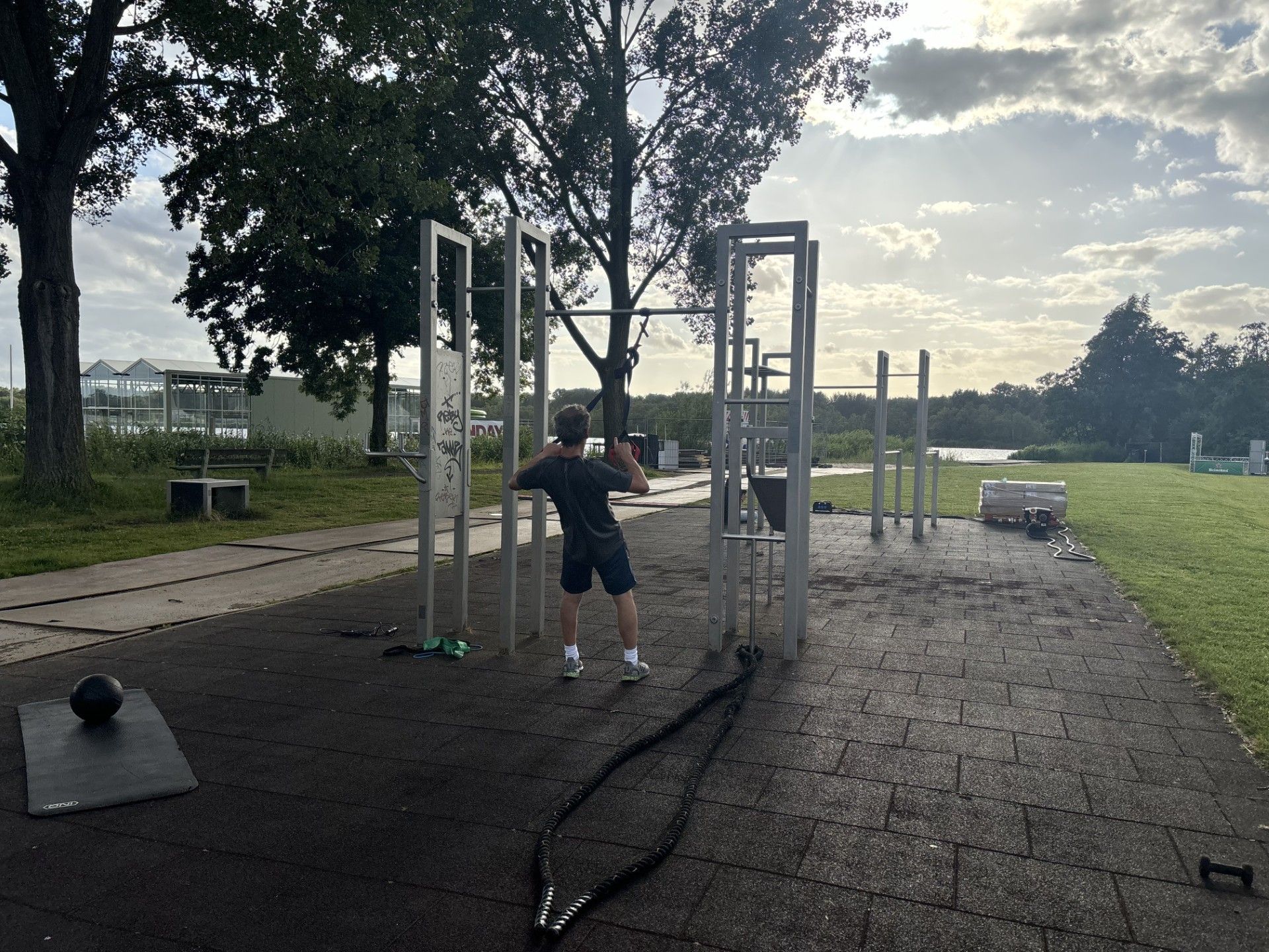 Buitenlocatie in Amstelveen voor personal training met pull-up bar en battle ropes in een groene omgeving.