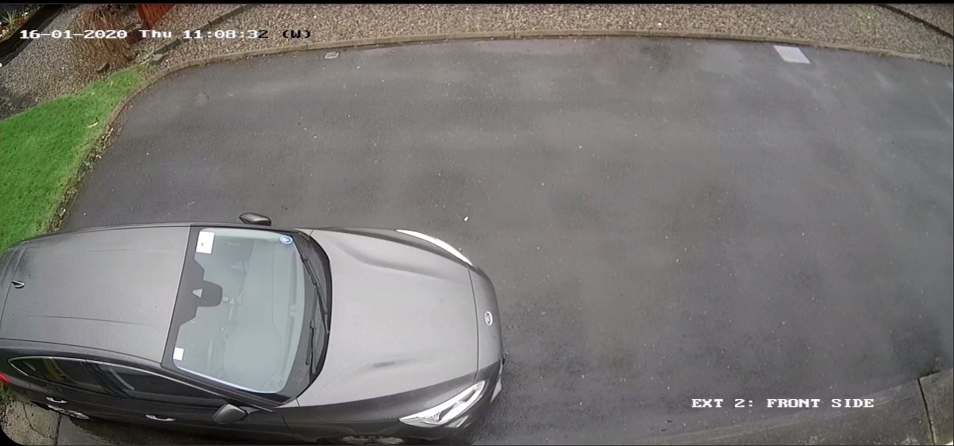A car is parked on the side of the road in a driveway.