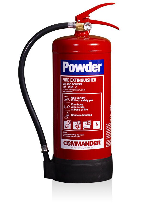 A red powder fire extinguisher is sitting on a white surface.