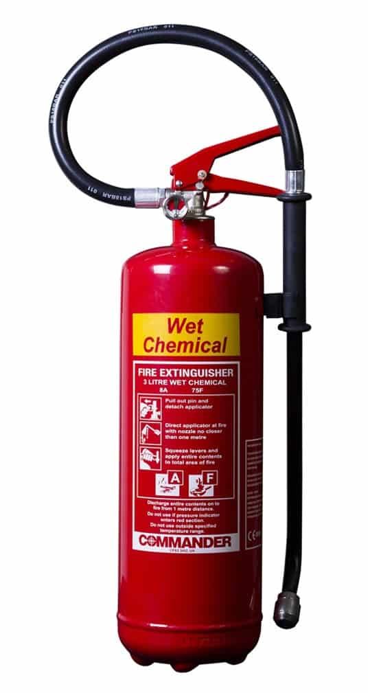 A red wet chemical fire extinguisher with a black hose attached to it.