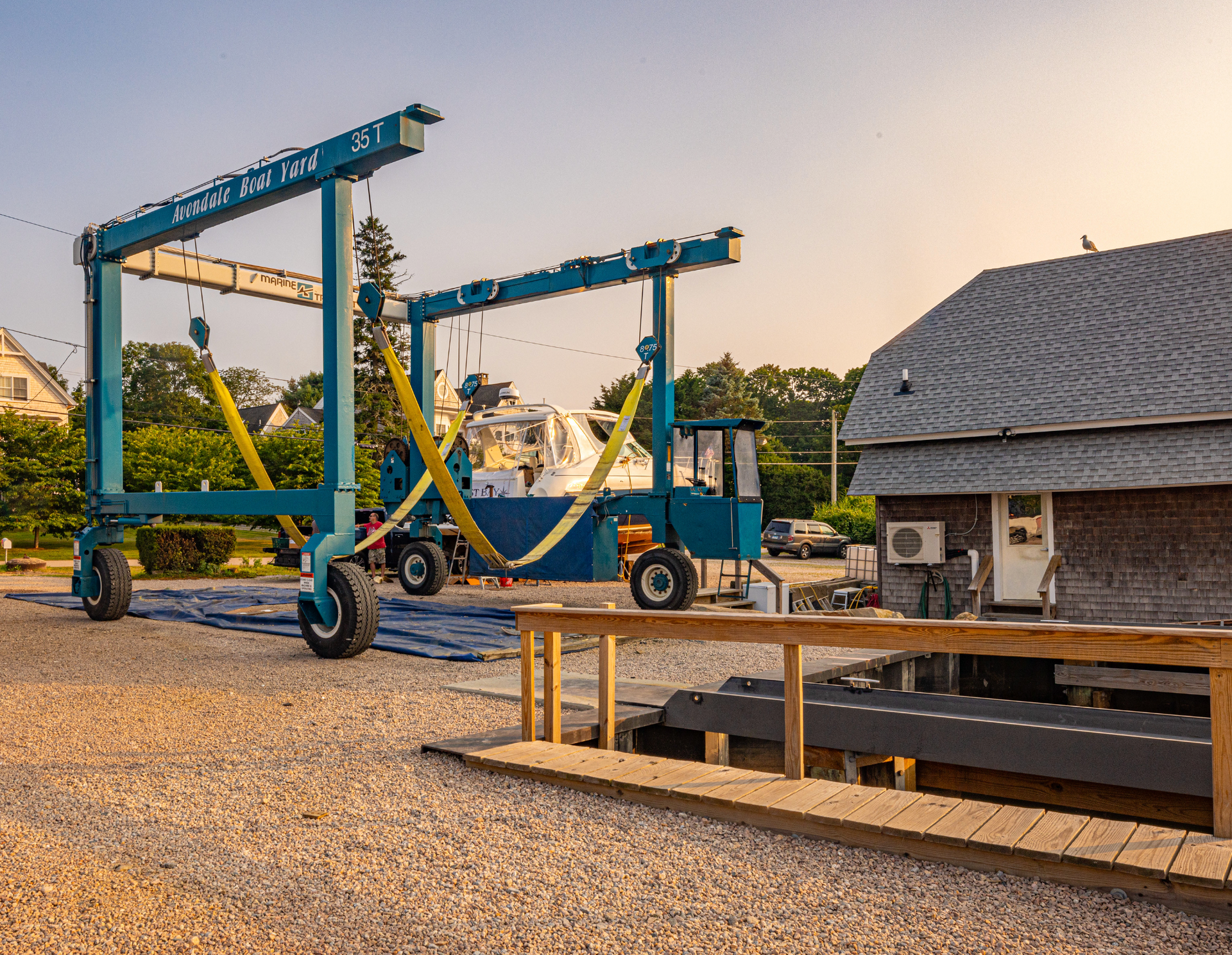 A boat is being lifted by a crane in front of a building.