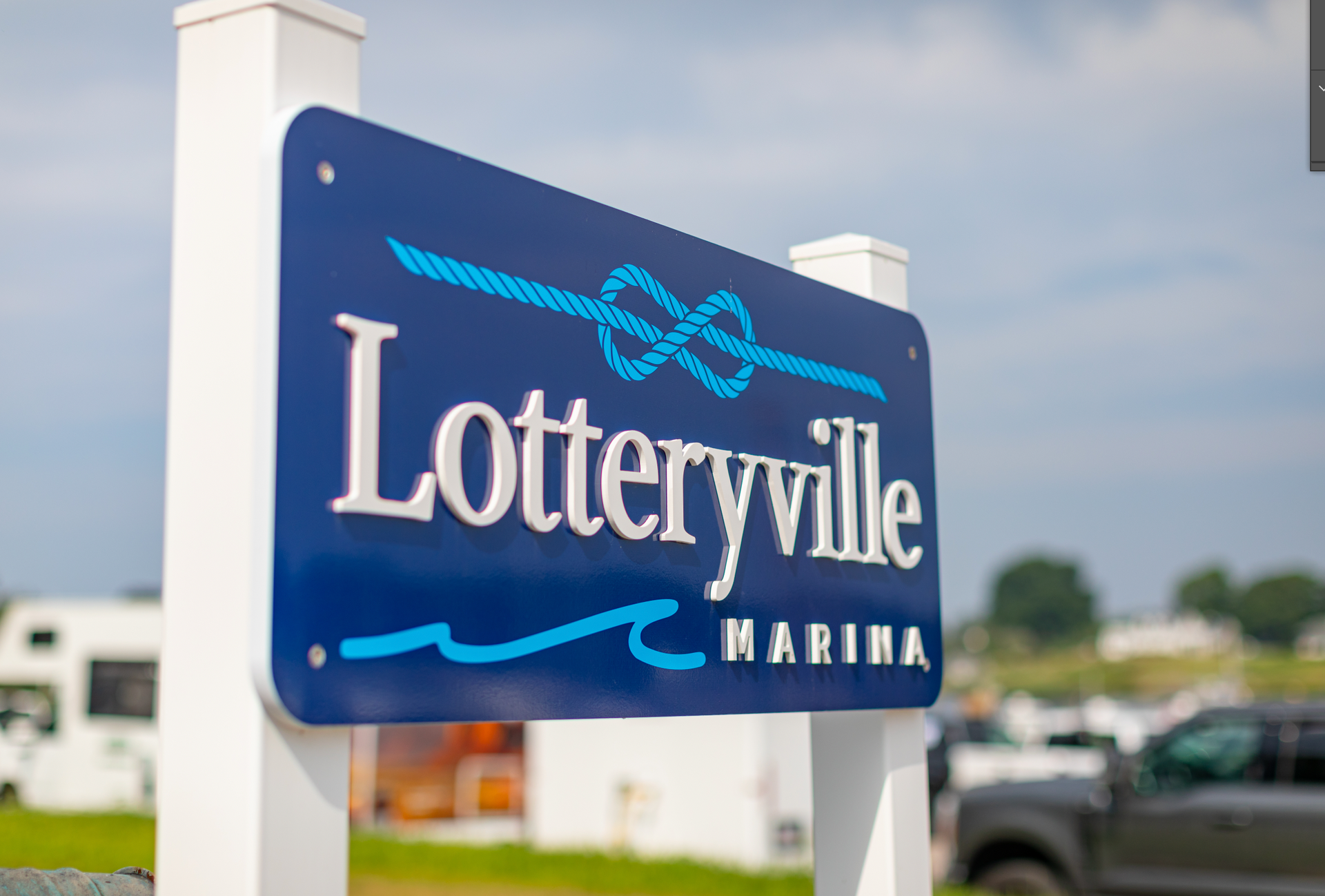 A blue and white sign for lotteryville marina