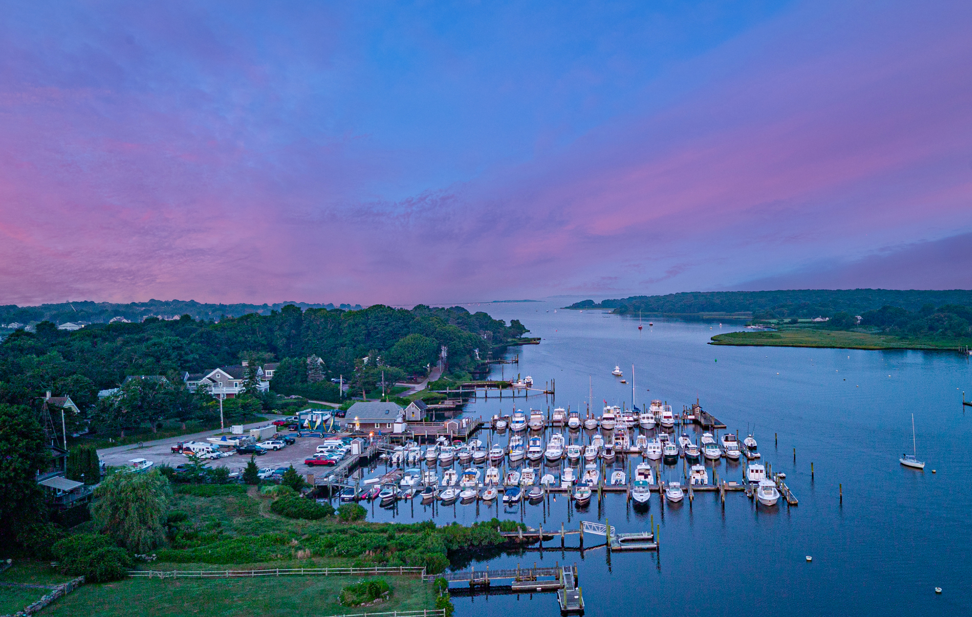 An aerial view of a marina filled with boats at sunset.