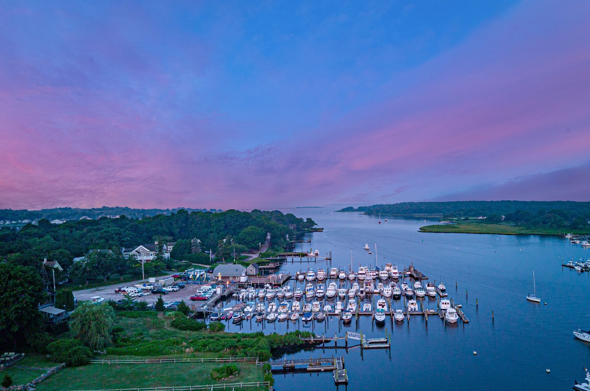 An aerial view of a marina filled with boats at sunset.