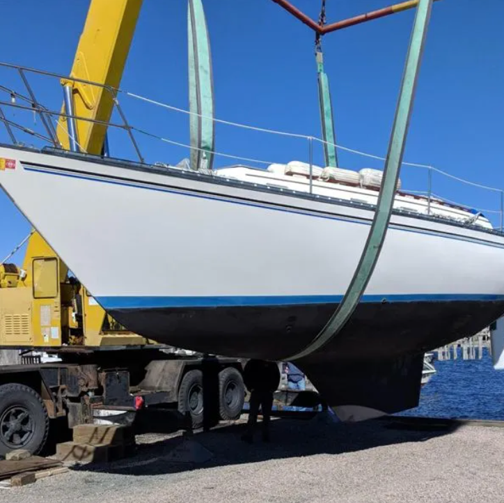A boat is being lifted into the water by a crane
