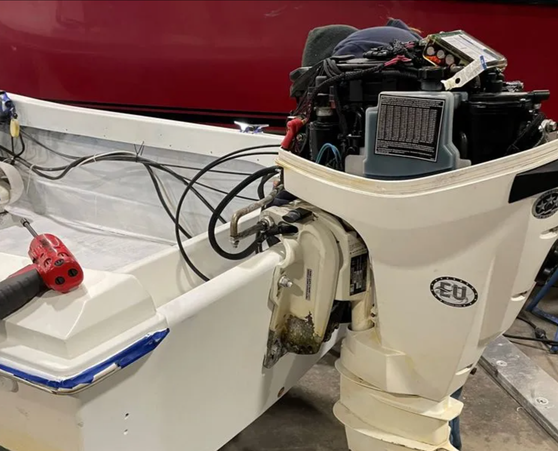 A white outboard motor is sitting on top of a white boat.