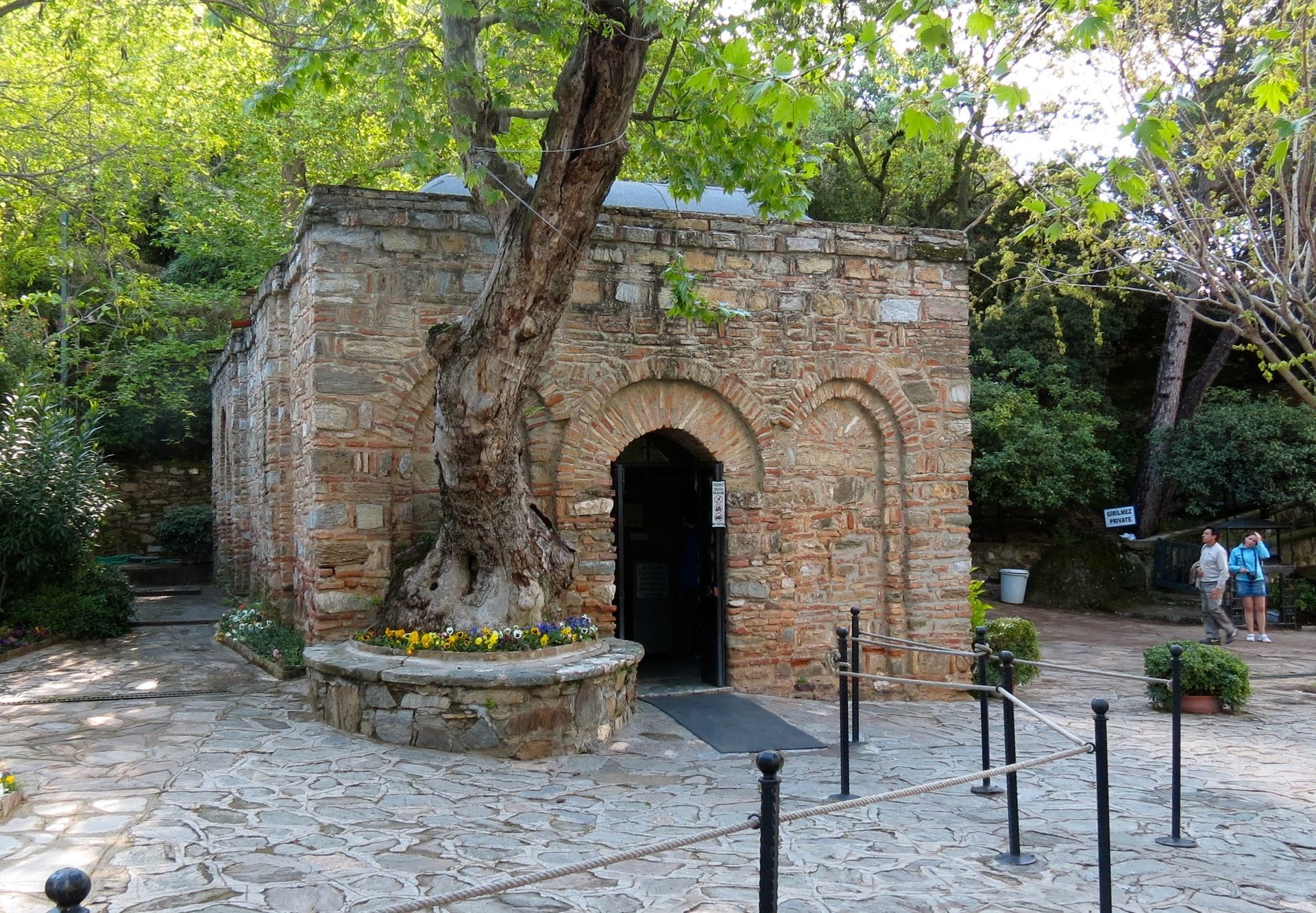 A stone building with a tree in front of it.