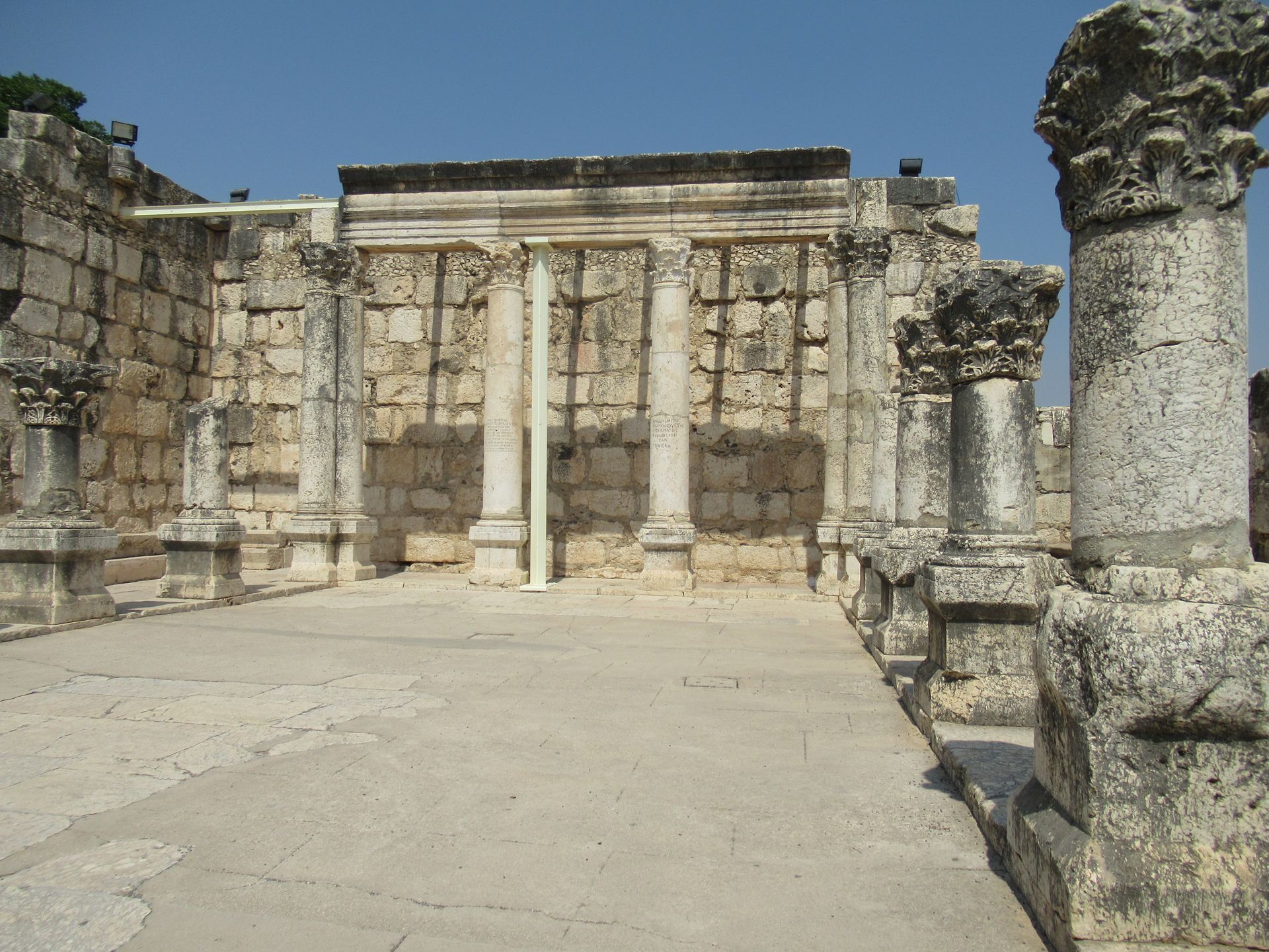 A stone building with columns and a blue sky in the background