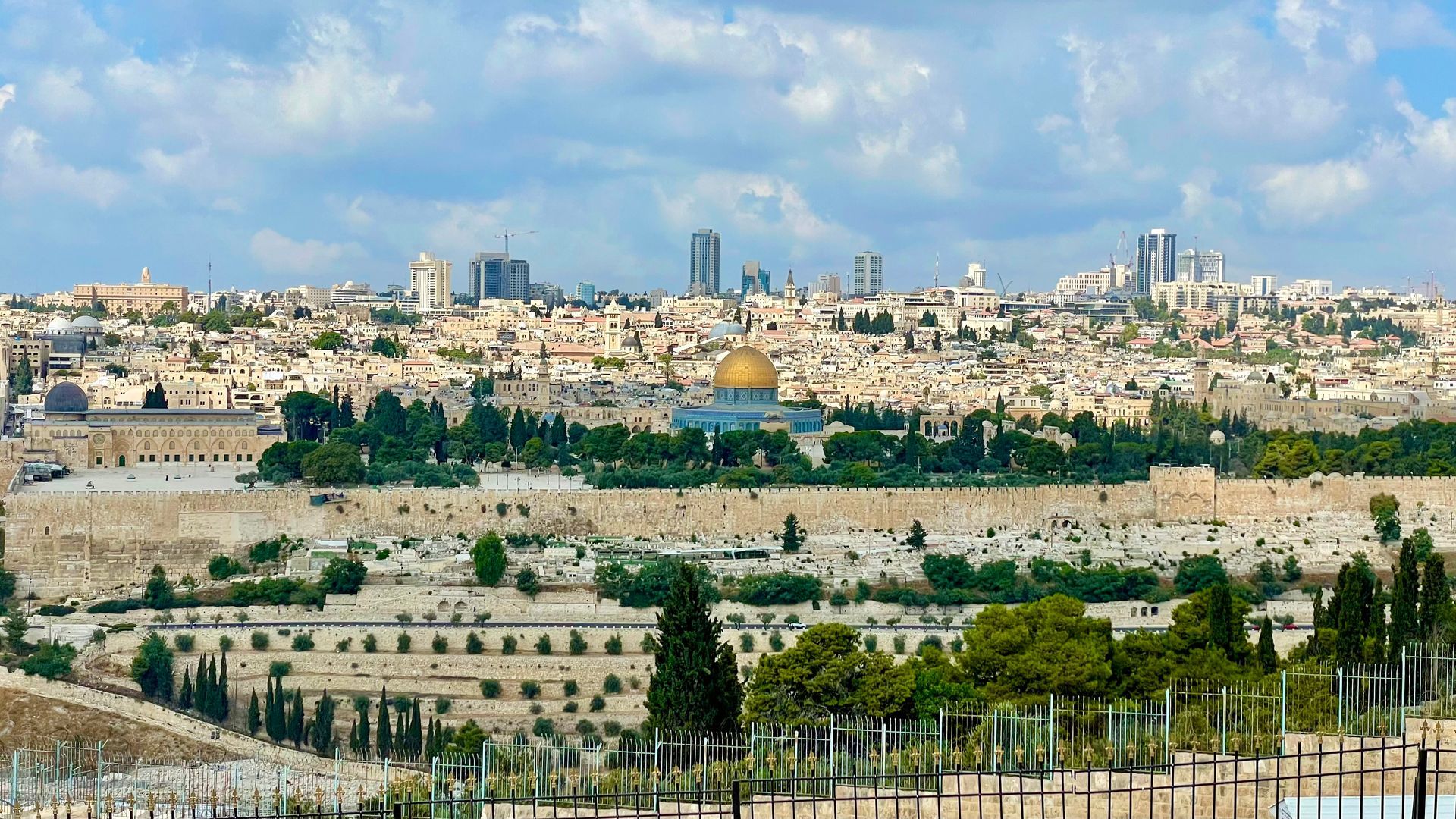 An aerial view of the city of jerusalem with the dome of the rock in the background.