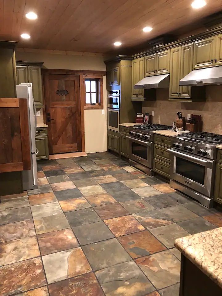 A kitchen with stainless steel appliances and a tiled floor.