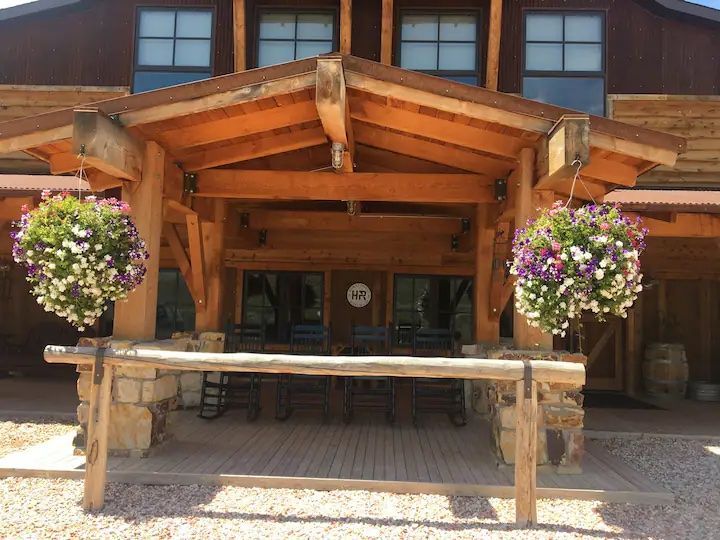 A large wooden building with flowers hanging from the roof.