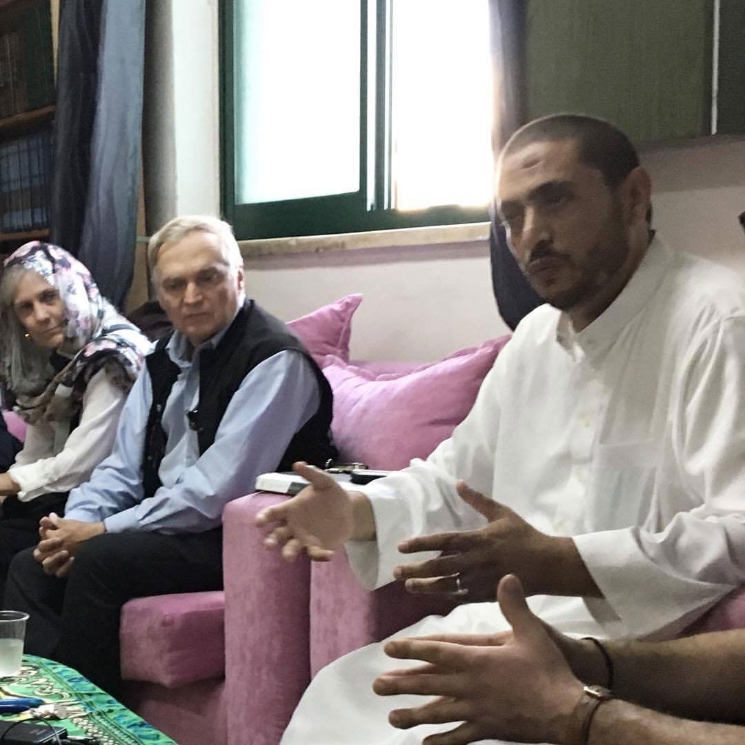 A group of people are sitting on a couch talking