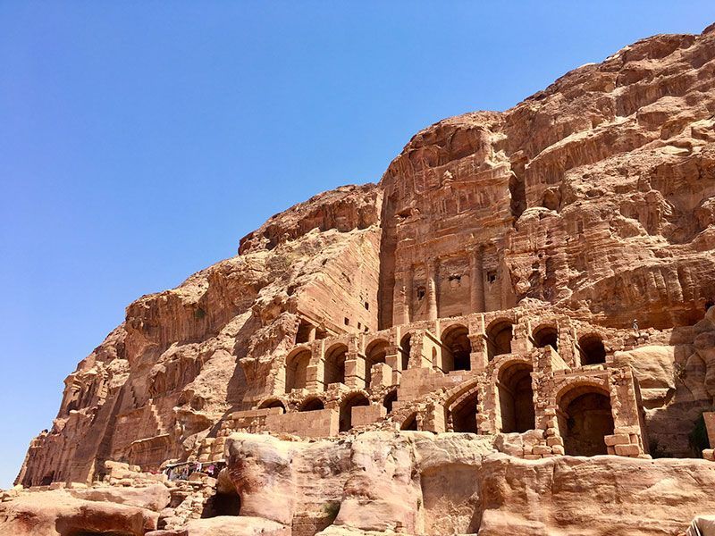 A large rock formation in Petra Jordan with a blue sky in the background.