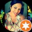A woman is smiling in front of an orange star