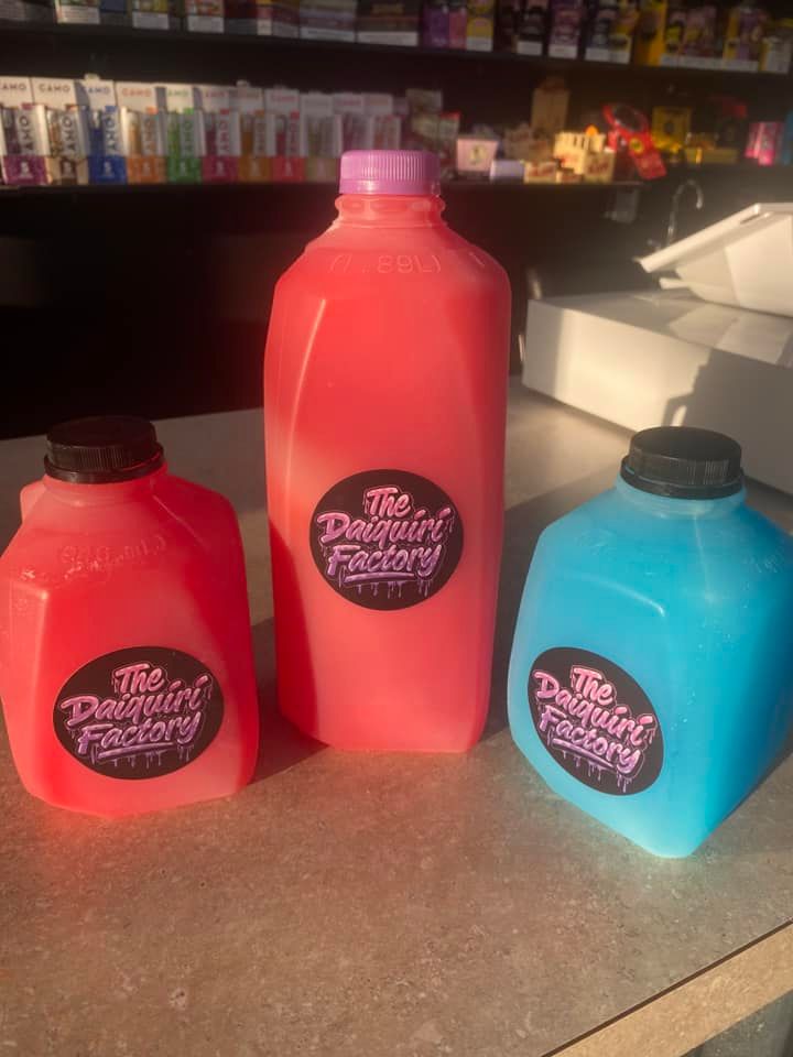 Three bottles of juice are sitting on a counter.