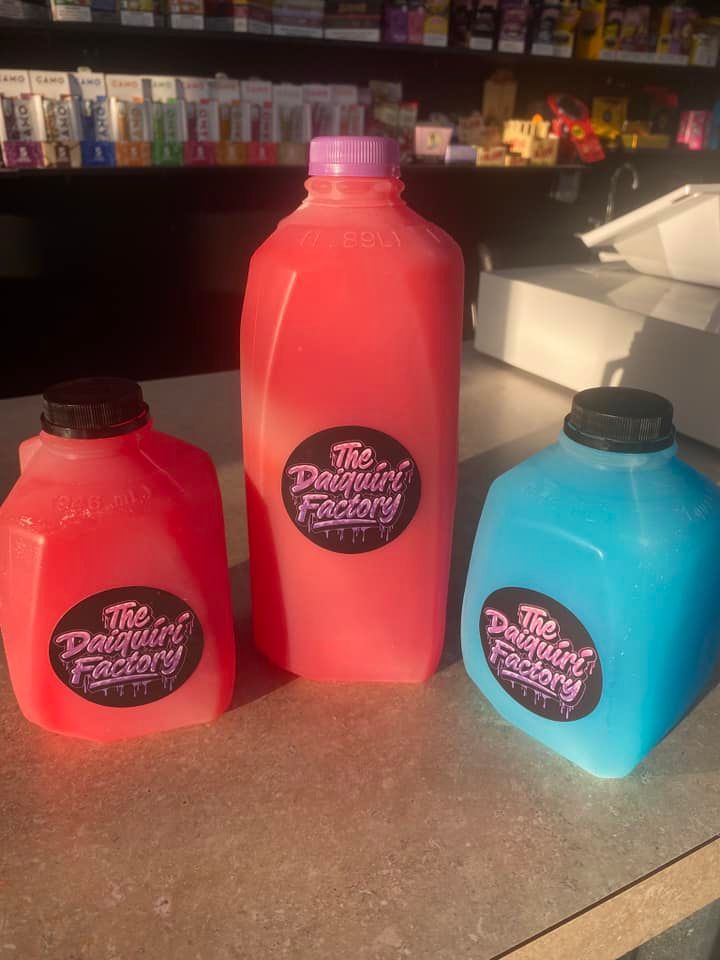 Three bottles of juice are sitting on a counter.