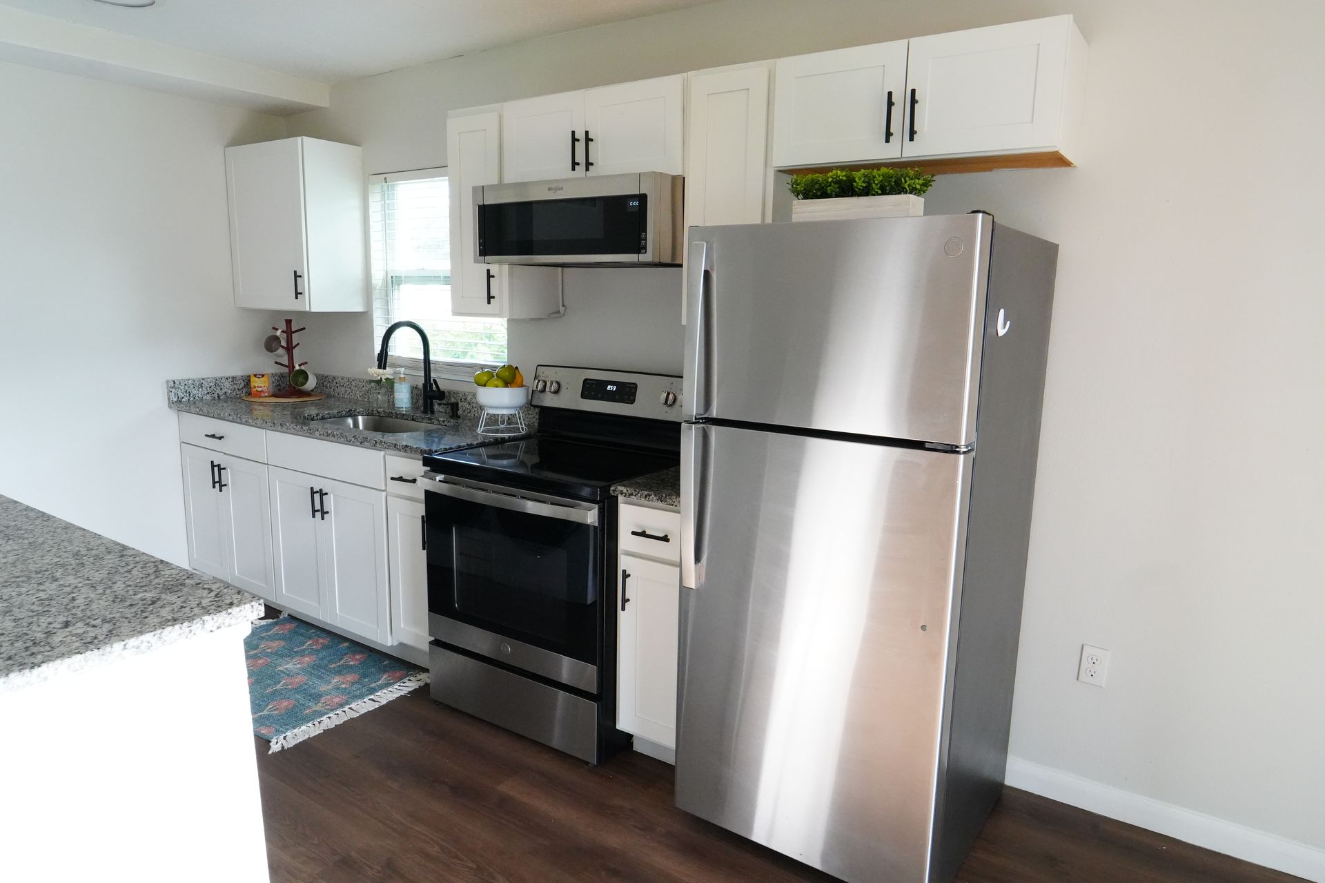 A kitchen with stainless steel appliances and white cabinets