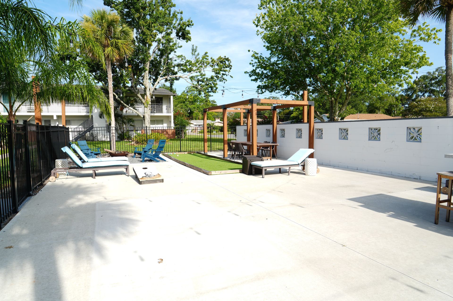 A patio area with blue chairs and a pergola