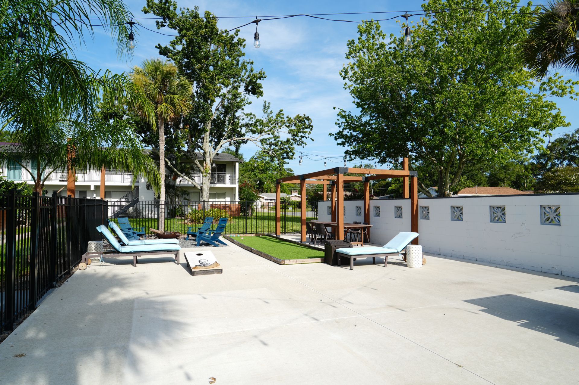 A patio area with blue chairs and a pergola