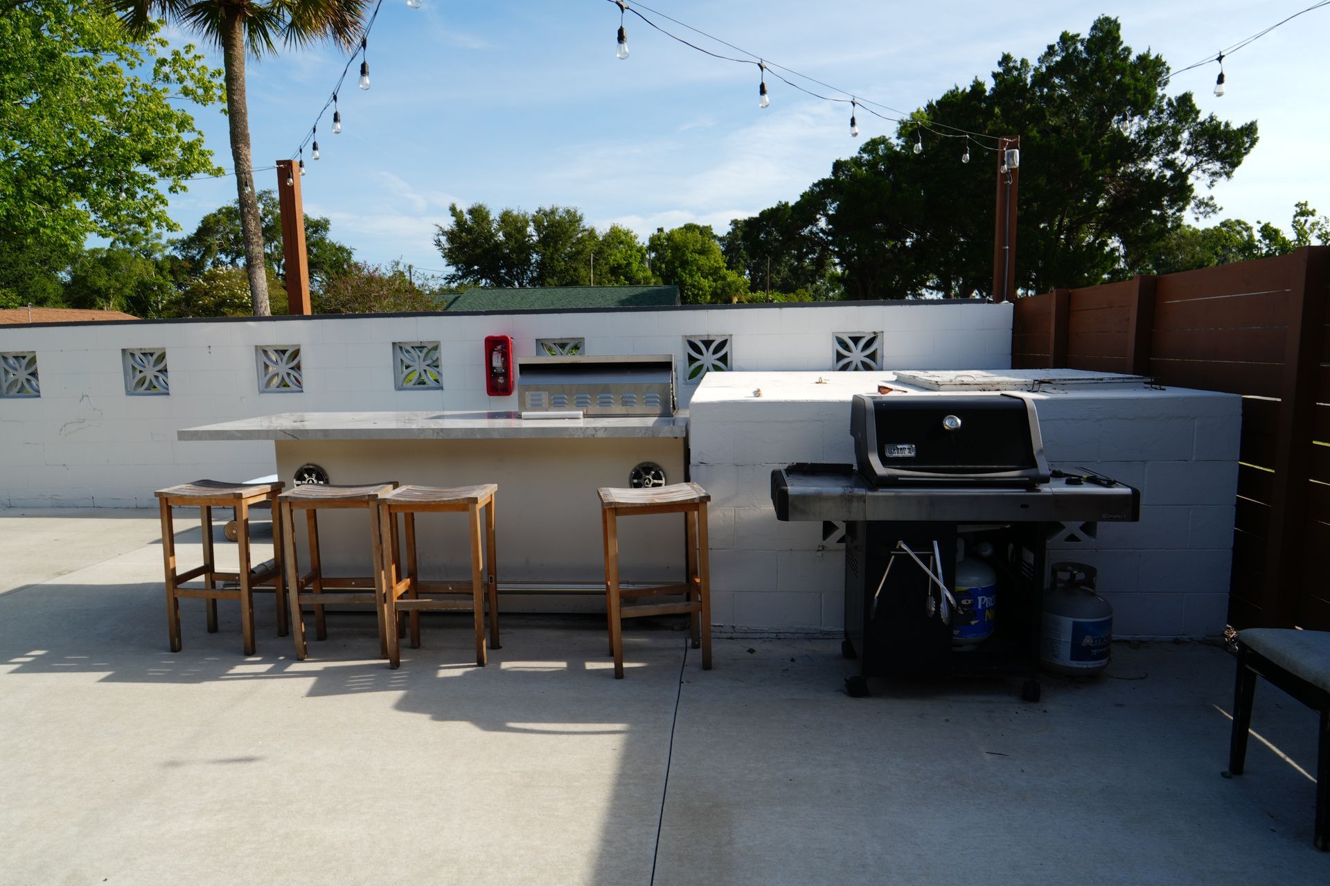 A patio area with a grill and stools