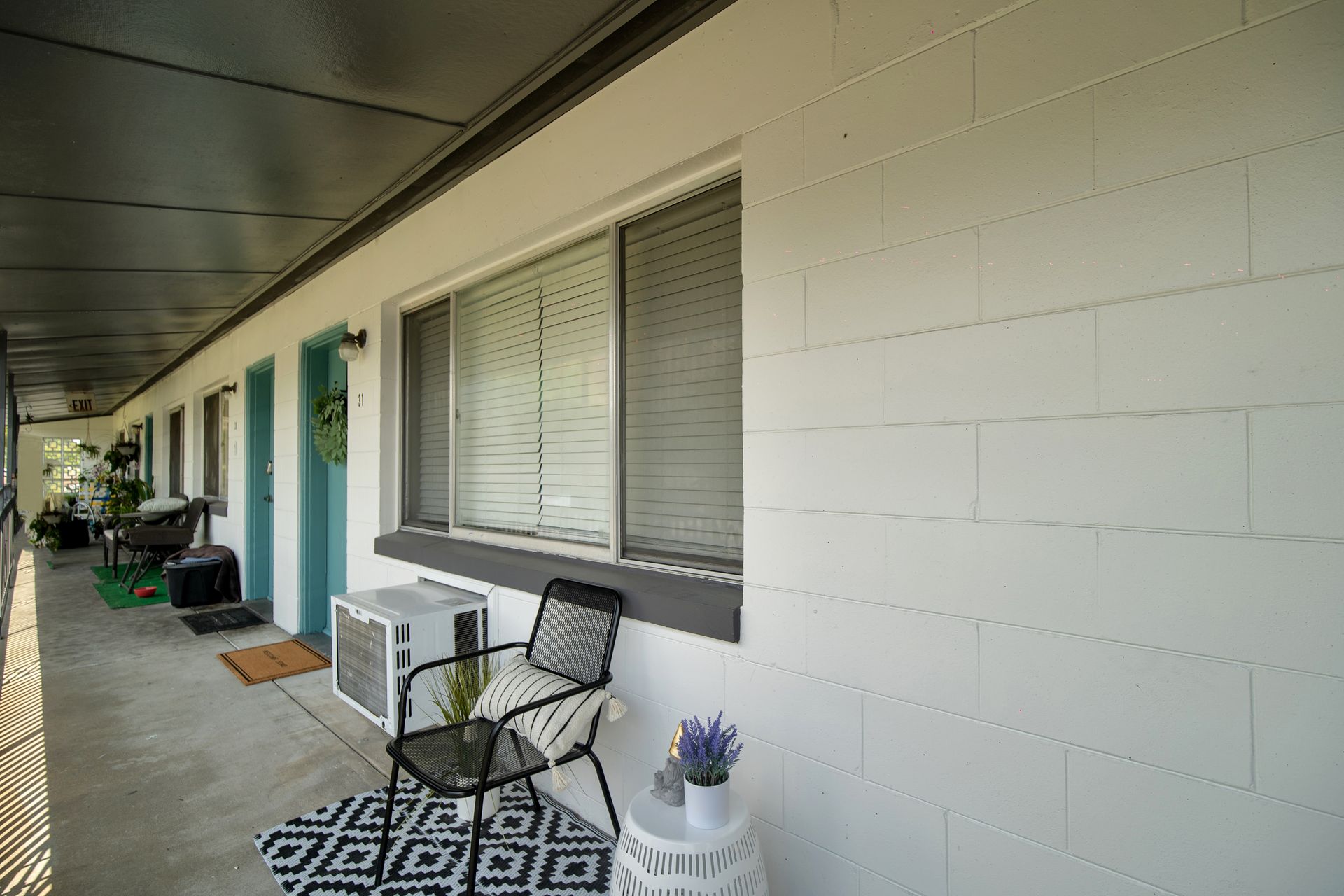 A balcony with a chair and a table in front of a building.