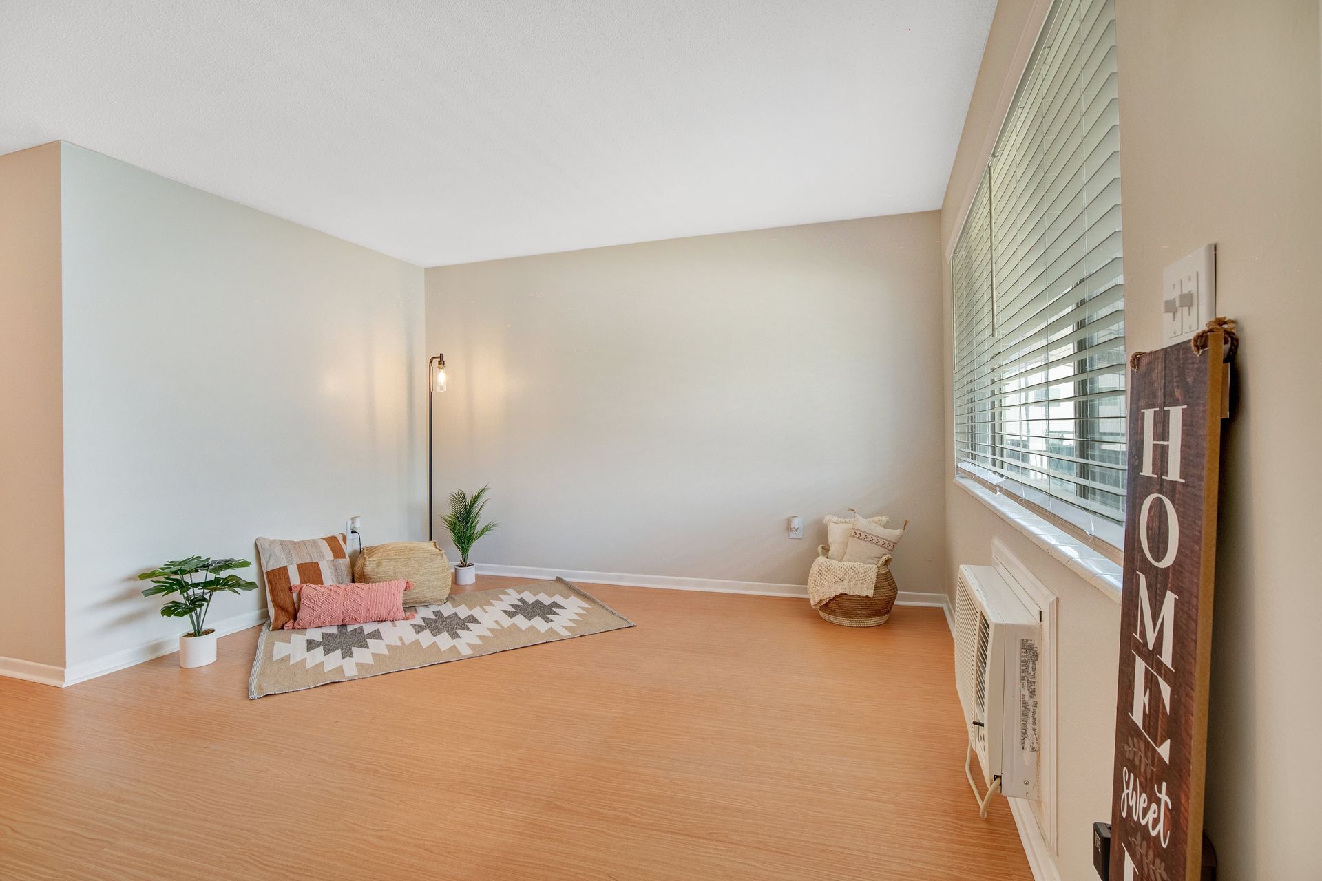 An empty living room with a sign that says home on it.