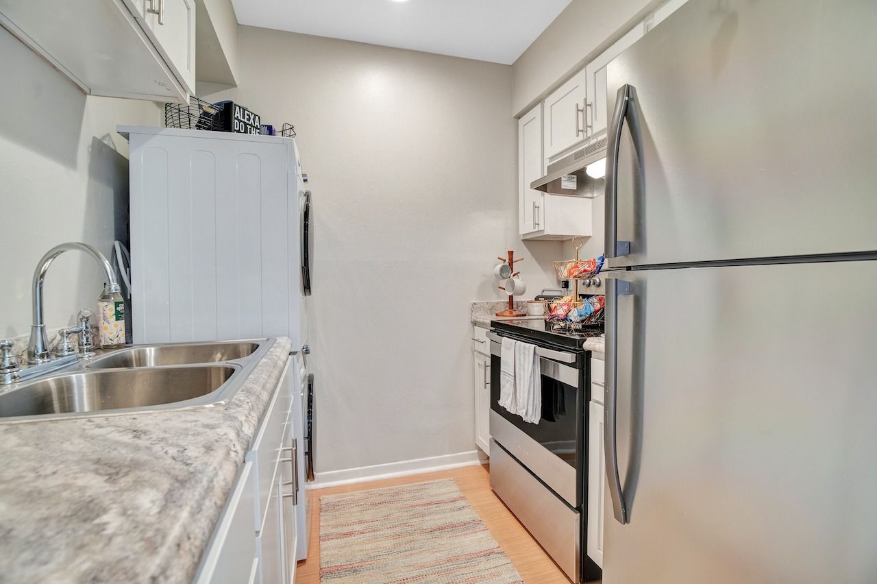 A kitchen with stainless steel appliances , a sink , refrigerator and stove.