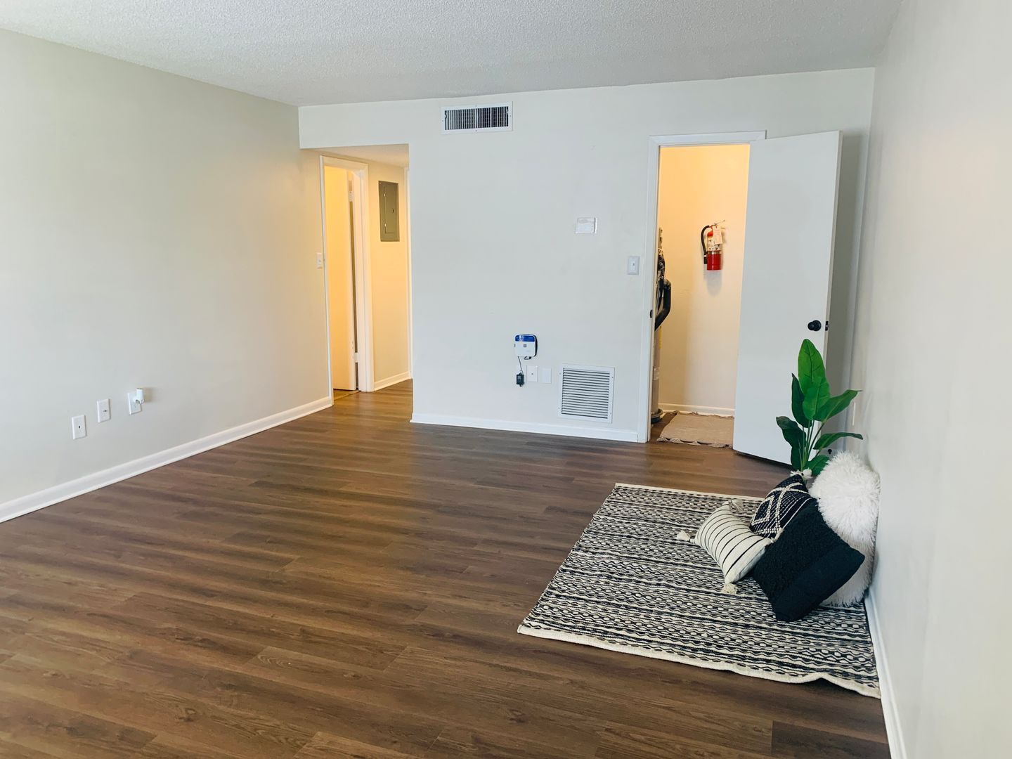A living room with hardwood floors and white walls.