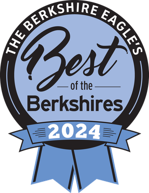 a woman is smiling in front of a banner that says best of the berkshires