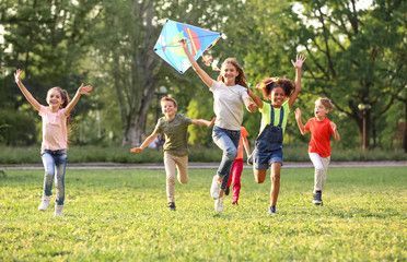 A group of children are flying a kite in a park.