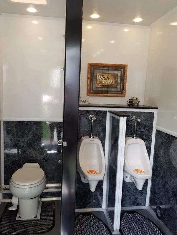 A bathroom with two urinals and a toilet