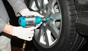 Man fixing tire — Safety Inspection in West Chester, PA Man fixing tire — Safety Inspection in West Chester, PA