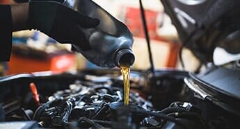 Man putting oil in the engine — Safety Inspection in West Chester, PA