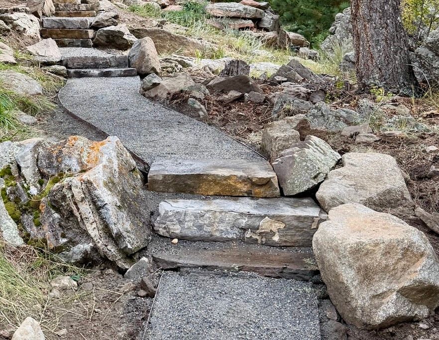 Stone steps and gravel path in a natural outdoor setting, leading uphill.