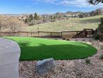 Green artificial turf in backyard with a scenic, hilly background.