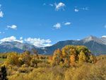 Mountains and fall foliage under a clear blue sky.