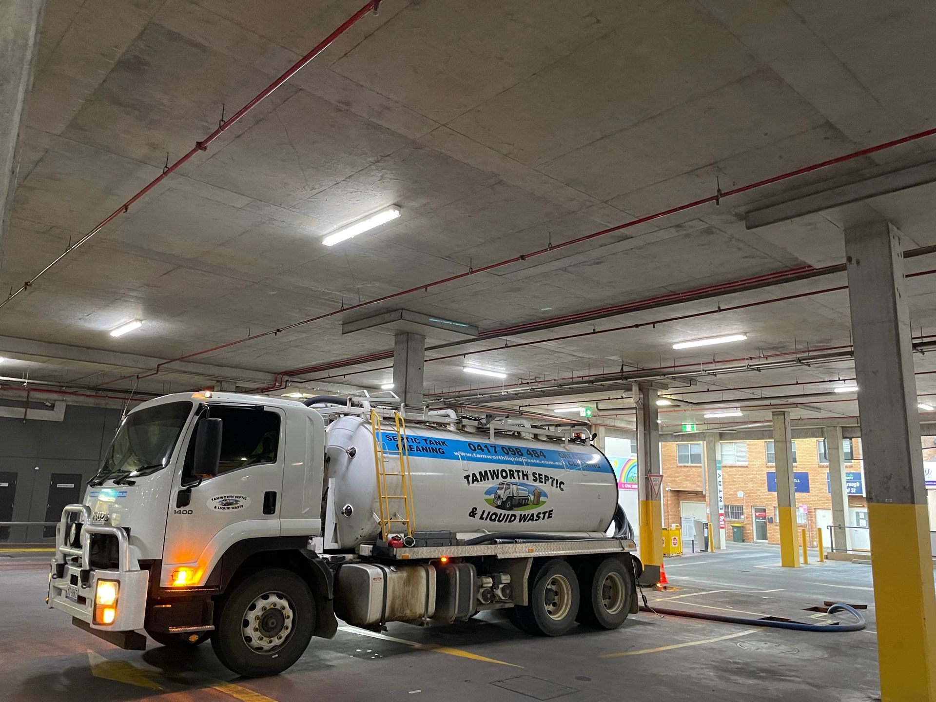 White Tanker Truck Parked in An Indoor Garage — Tamworth Septic & Liquid Waste in Gunnedah, NSW