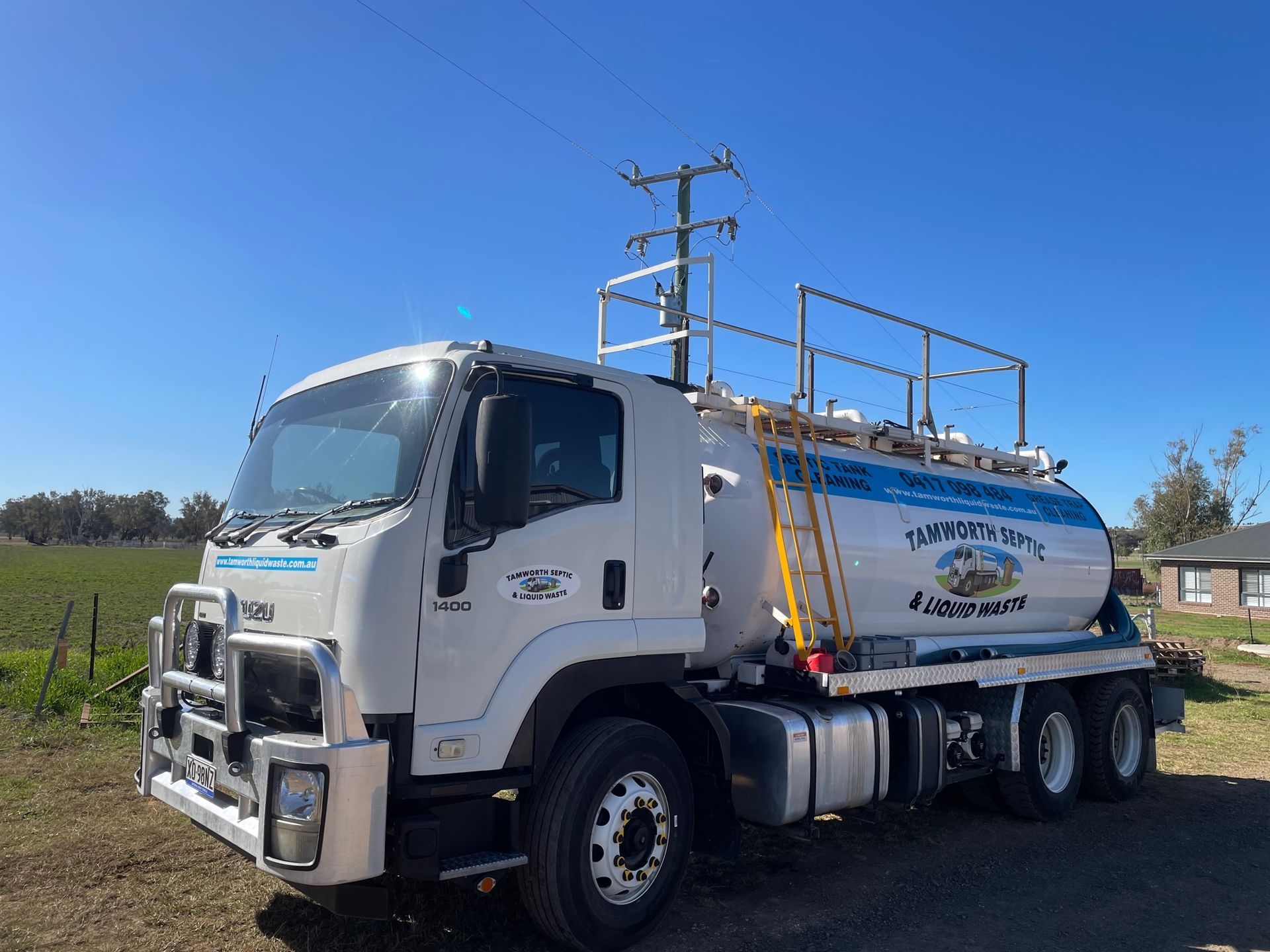 White Tanker Truck Parked on A Rural Roadside Under a Clear Blue Sky — Tamworth Septic & Liquid Waste in Wallabadah, NSW