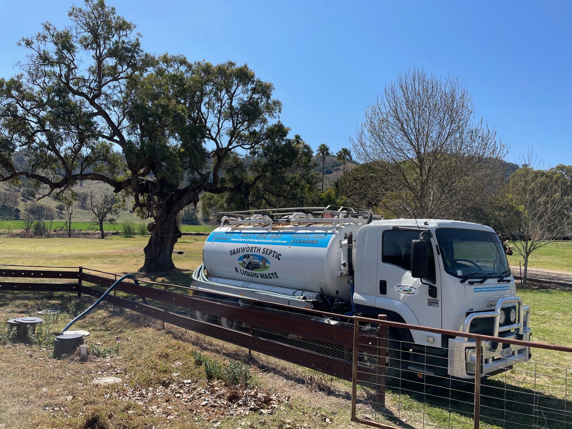 White Tanker Truck Parked by A Fence in A Grassy Field — Tamworth Septic & Liquid Waste in Manilla & Barraba, NSW