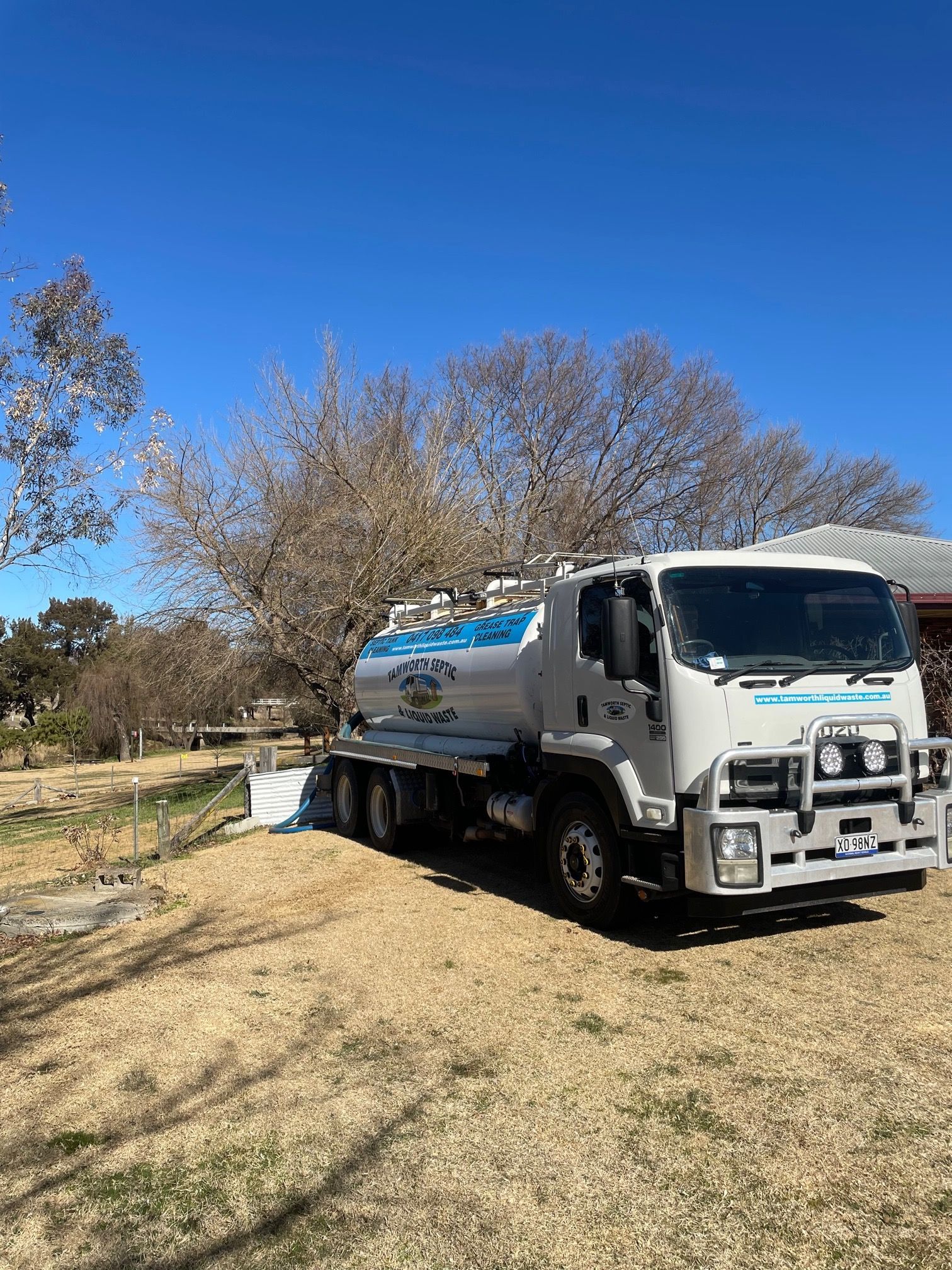 White Water Tanker Truck Parked Beside a Dirt Road Under a Clear Blue Sky — Tamworth Septic & Liquid Waste in Wallabadah, NSW