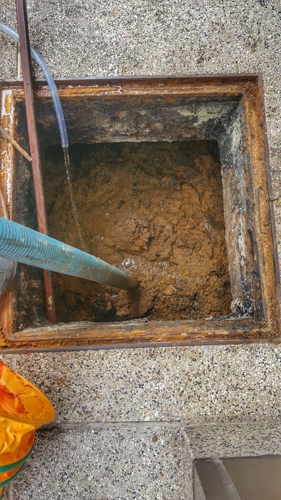 Manhole with Muddy Water and A Hose Draining Into It on A Concrete Surface — Tamworth Septic & Liquid Waste in Quirindi, NSW