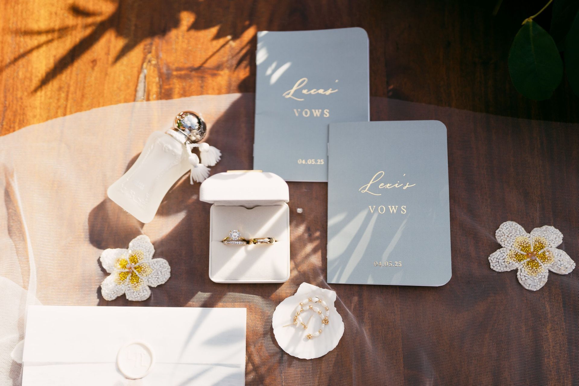 Wedding rings, vow cards, and decorative elements on a wooden table.