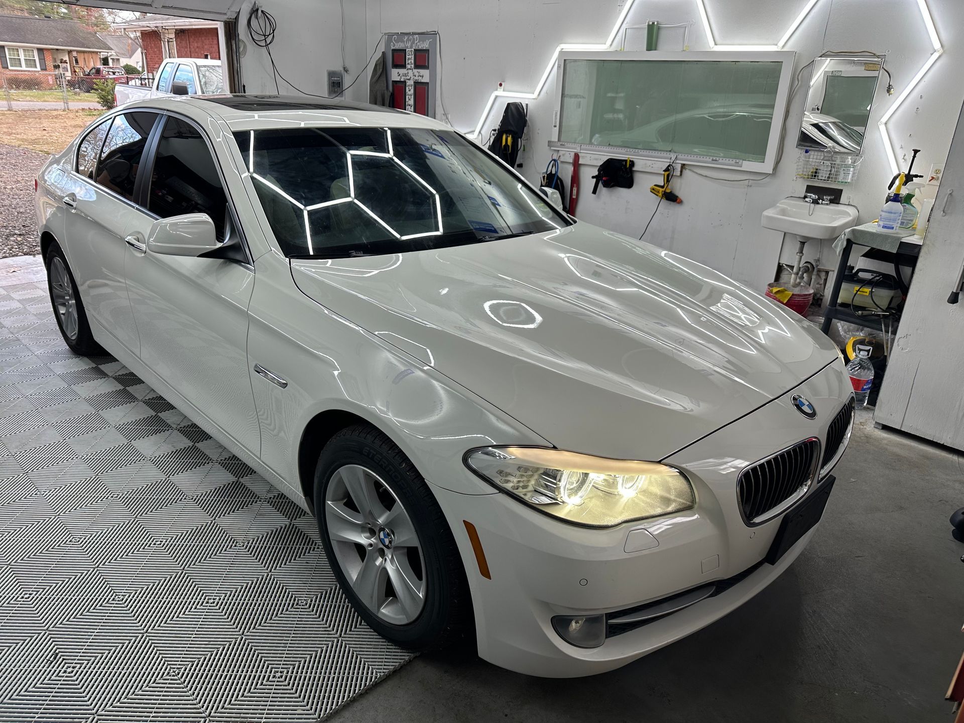 A white bmw is parked in a garage.
