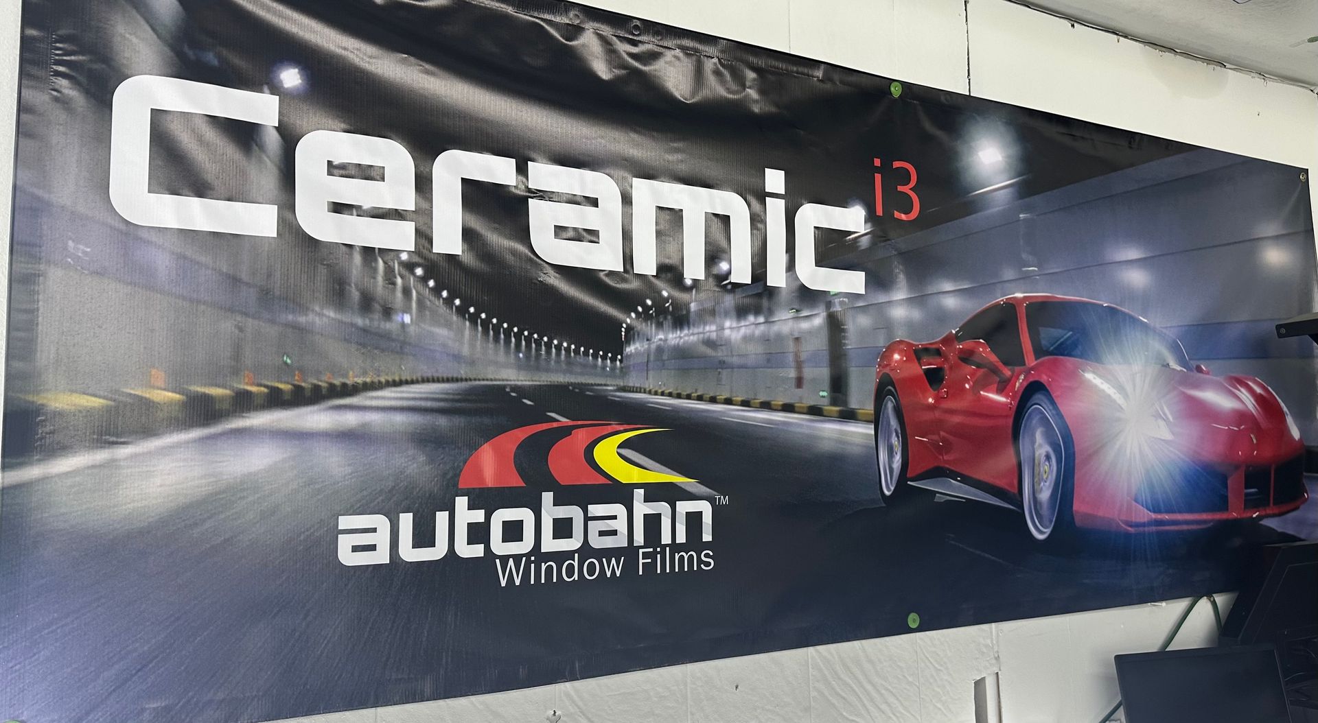 A red car is on a sign that says ceramic 13 autobahn