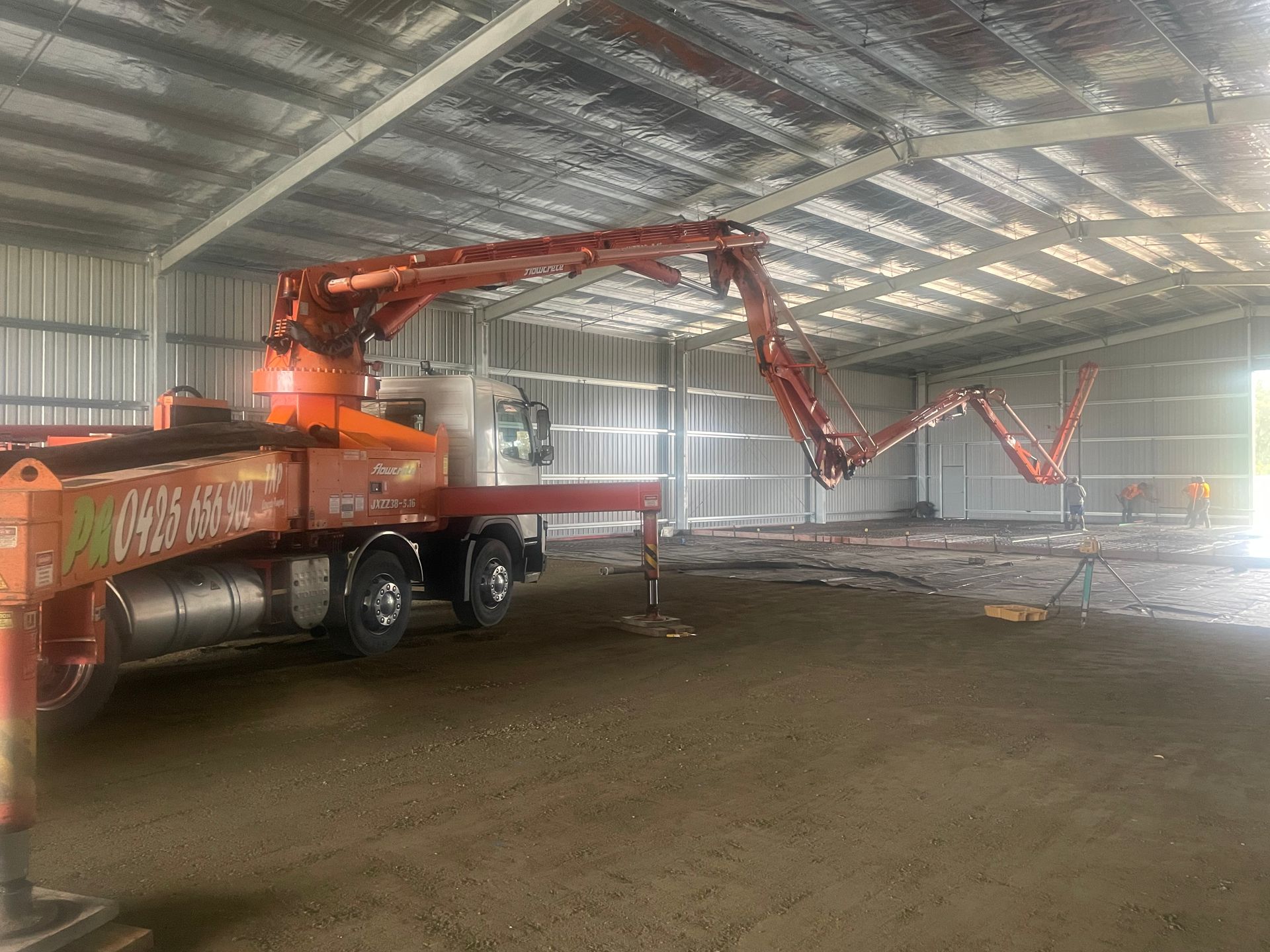A concrete pump truck is sitting inside of a building.