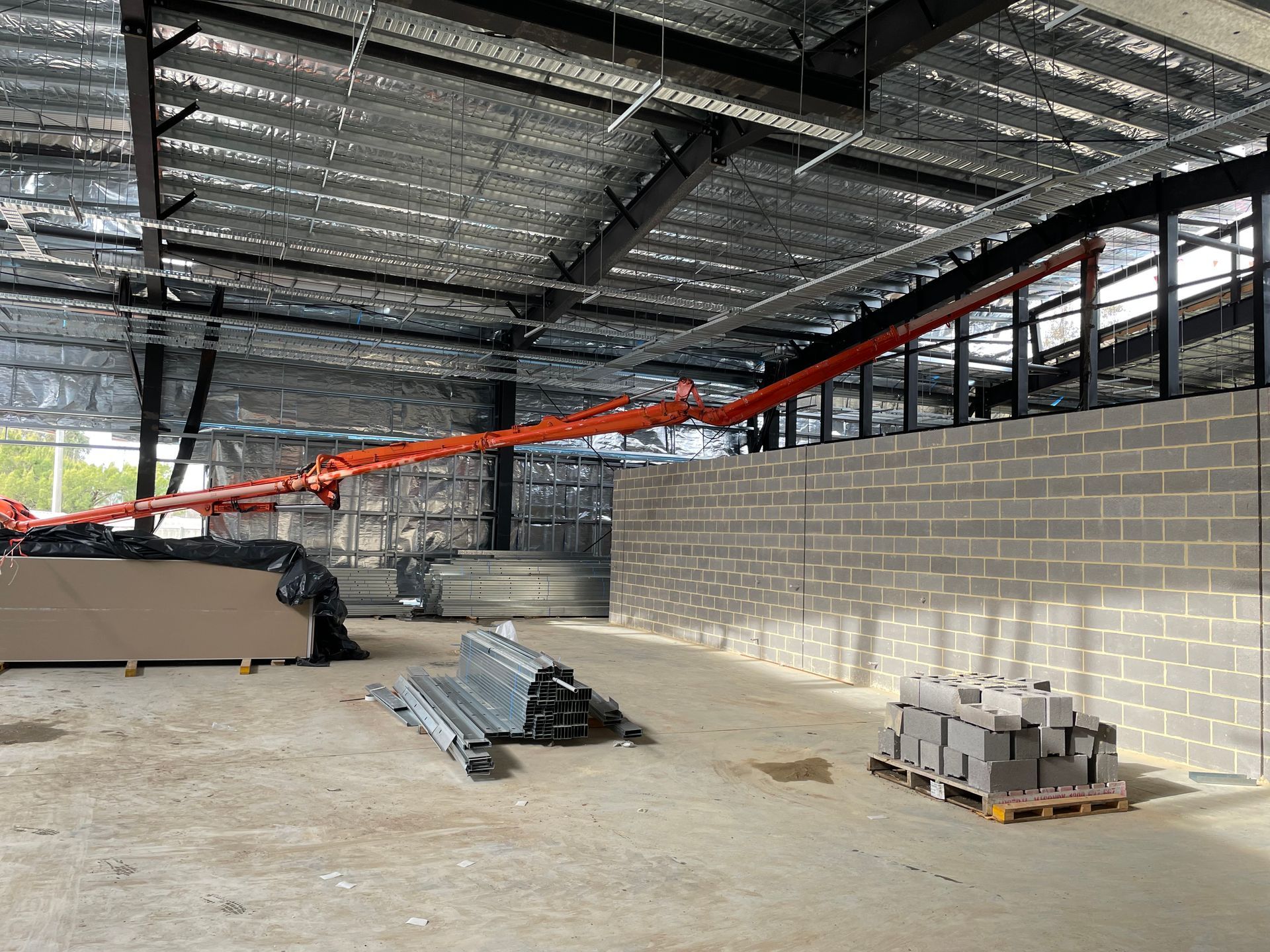 An empty warehouse with brick walls and a crane in the background