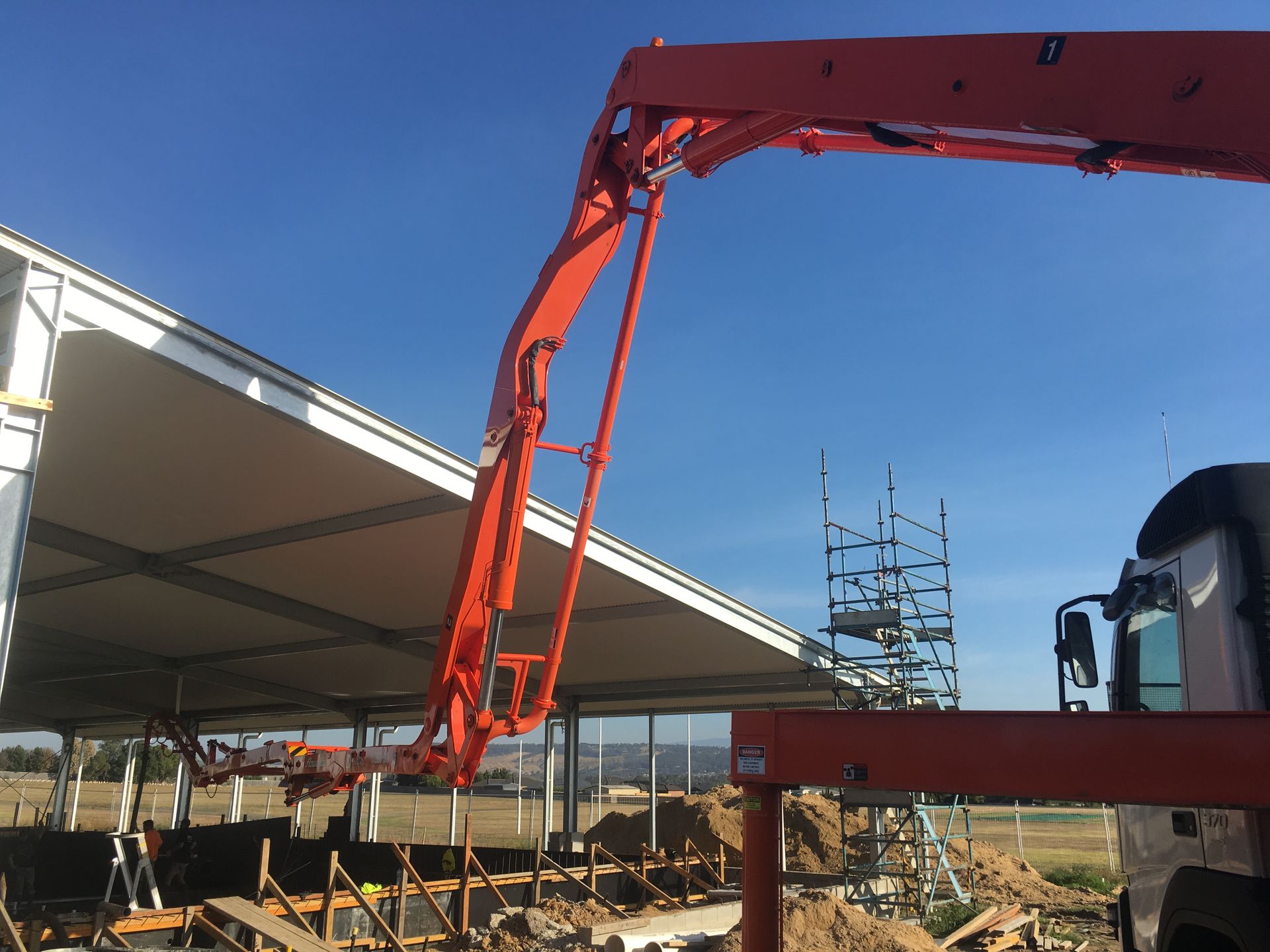 A crane is being used to pump concrete into a building under construction