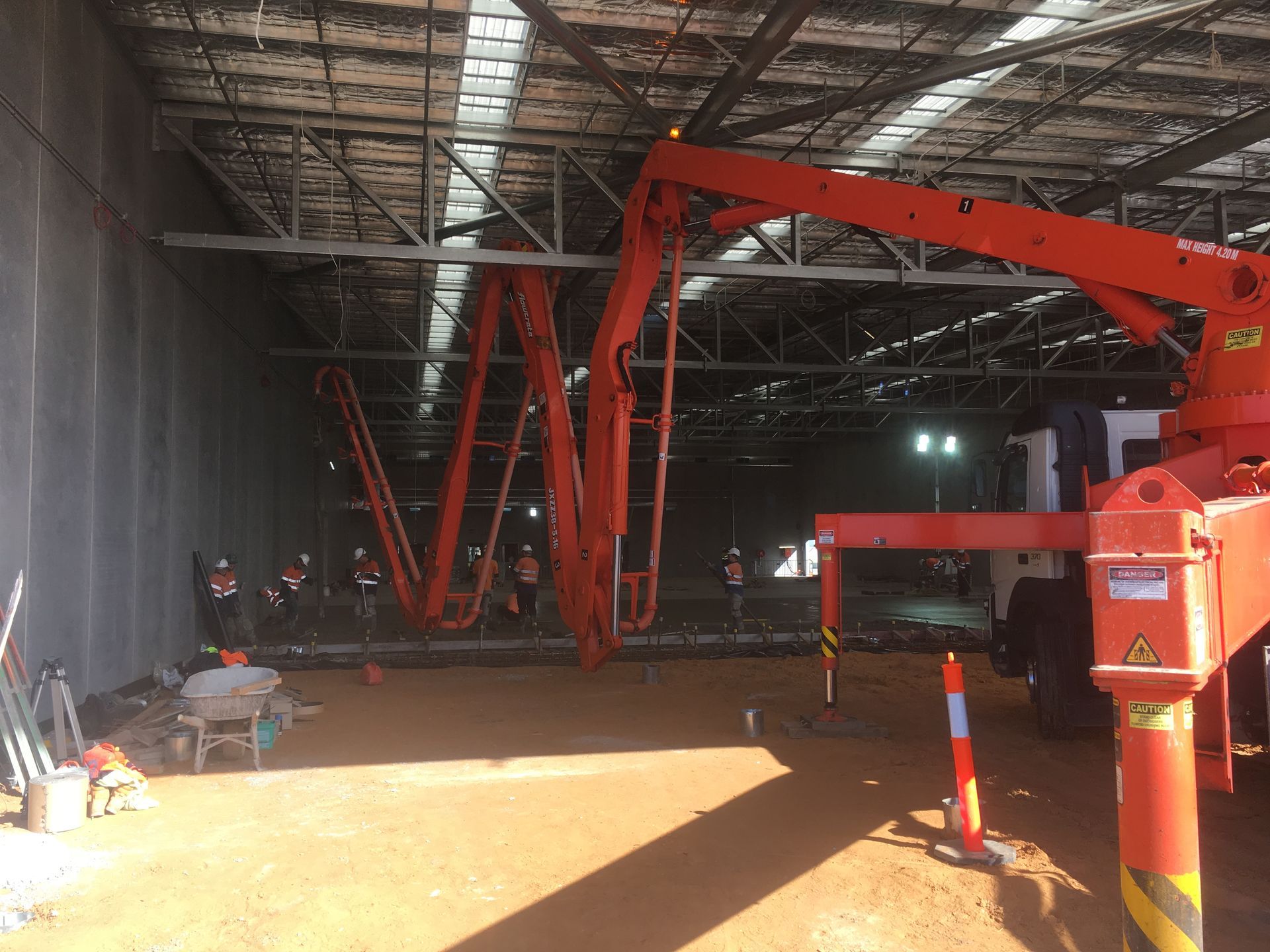 A concrete pump is being used to pour concrete into a building.