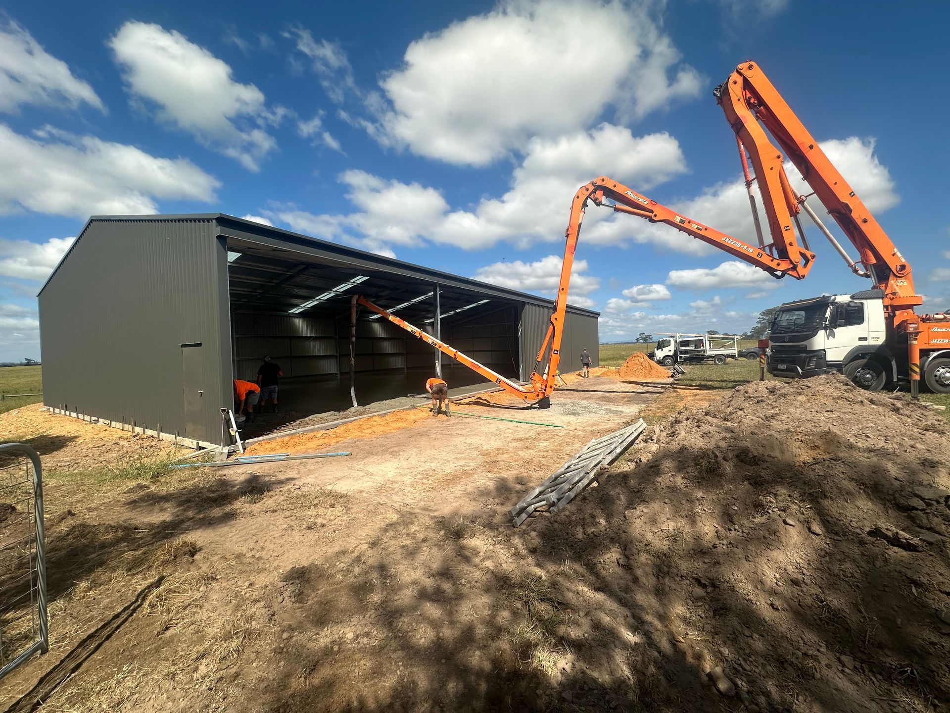 A concrete pump is being used to pour concrete into a building.