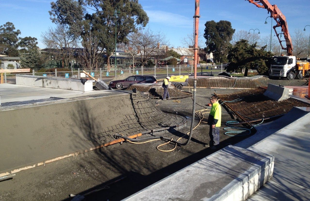 A concrete pump is being used to pour concrete into a pool